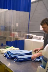 Employé de Ménagez-Vous triant le matériel lavé pour le redistribuer sur les différents sites clients.